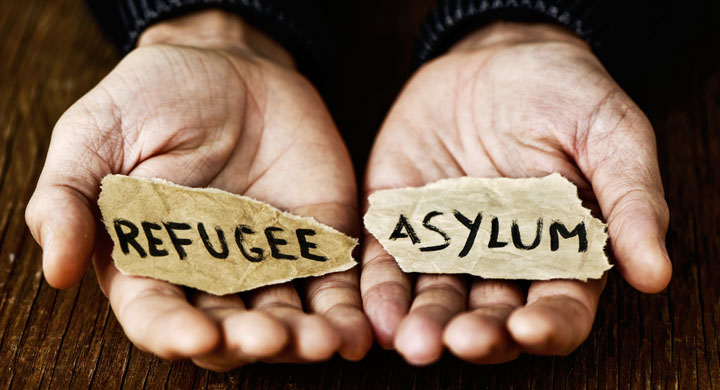Hände die Zettel mit den Worten Refugee und Asylum halten